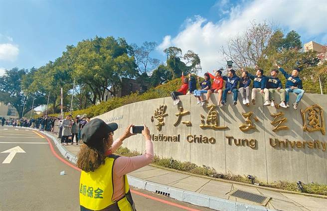 國立交通大學校名25日正式走入歷史，昨天是與「國立交通大學」校名合照的最後機會，一早即有大批校友排隊搶拍。（陳育賢攝）
