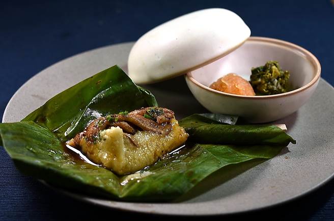 〈T＋T〉冬季新菜〈松阪猪／小米／渍菜〉 包在芭蕉叶内的小米饭，作法和义大利Polenta玉米糕相似，口感软糯中带着Q弹，松阪猪炭烤后并用蜂蜜炒制上色。（图／姚舜）