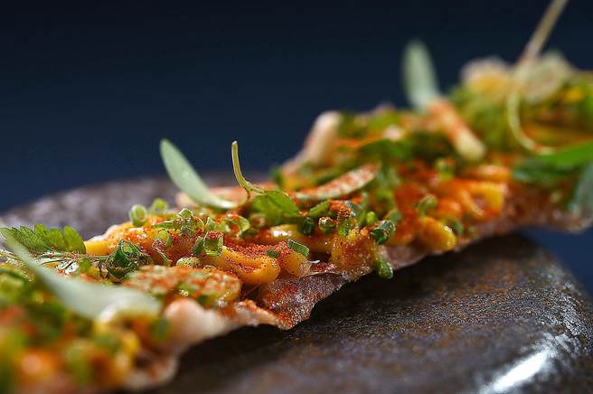 〈T＋T〉冬季菜式〈虱目鱼／咸蛋黄／香草〉，是以新加坡的「咸蛋黄鱼皮」为灵感创作。（图／姚舜）