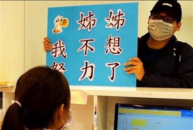 「姊姊我不想努力了」，员警扮演歹徒搭讪，高举现在流行语的看板，没想到行员镇静的回说「但是我结婚了」。（警方提供／卢金足台中传真）