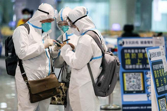 农历春节将届，桃园机场入境旅客较之前增加不少。图为桃园机场旅客穿防护衣入境。（陈麒全摄）