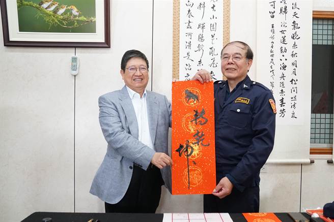 書法家謝長有（右）現場揮毫「牛轉乾坤」贈給縣長楊文科（左）。（羅浚濱攝）
