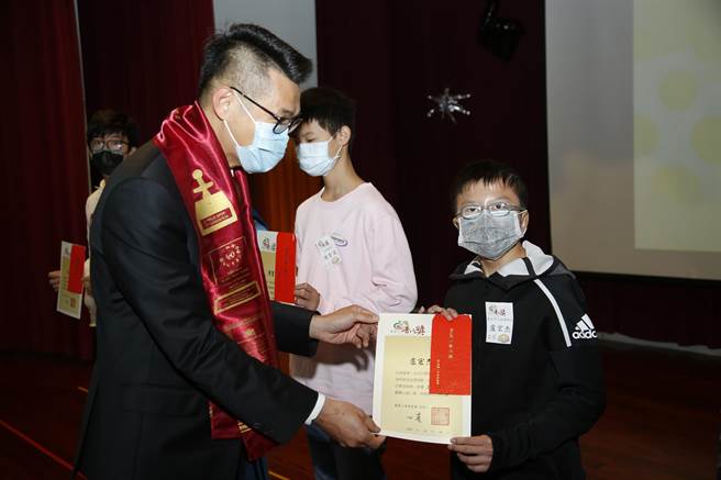 就读台北市启聪学校国中部的卢宏杰（右），接受台北市普仁奖表扬。（图由灵鹫山佛教教团提供）