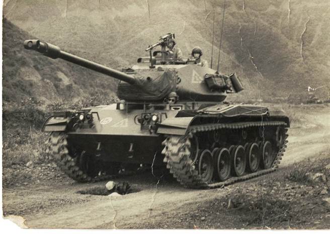 拍摄军事演习画面工作照。拍摄地点在南投车埕一带军事基地。
为捕捉坦克车行进画面特殊视角，摄影师范金玉藏身在特地挖出的坑洞里拍摄。
此珍贵画面亦被收录进当时电影开映前必播的国歌影片中。（范金玉提供）
