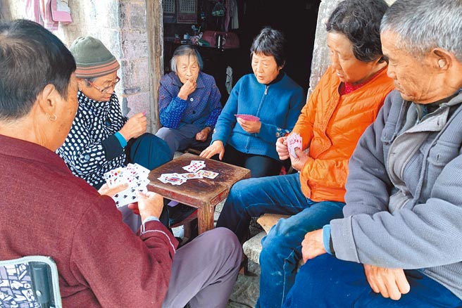 大陆陷入20年来出生率最低、老龄化加剧的困局。图为安徽省一农村，老年人在家门口打牌消遣。（中新社）