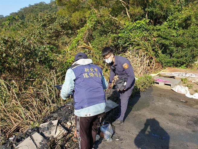 环保稽查员偕同警方至现场勘查，发现林男未妥善处理余烬，反而将其推下山坡，以致闷烧冒烟。（新北市环保局提供／叶德正新北传真）