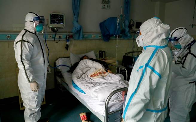 2020年，2月3日，武警湖北省总队医院隔离病房内，医务人员查房。（中新社）