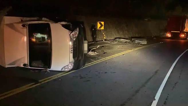 台东县台11线加母子湾路段，傍晚18点42分许发生一起货车对撞翻车事故，警消获报赶抵现场，事故造成2女、1男皆受轻伤、意识清醒，另1名男子受困车缝中，经消防人员救出时，已无生命迹象，目前送往台东马偕医院抢救中。（蔡旻妤摄）
