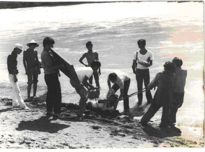 在沙滩上被拖行中的摄影师范金玉，工作中一景。（范金玉提供）