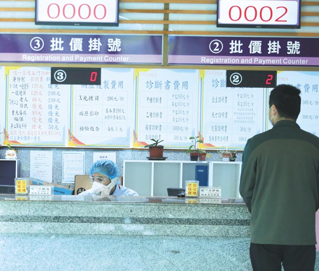 25日中老年患者前往桃醫拿藥，掛號櫃台的工作人員穿戴防護裝備服務病患。(陳怡誠攝)