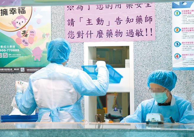 桃医爆发院内群聚感染事件已长达2周，累积多例确诊个案，中央疫情指挥中心扩大匡列人数至5000人，引起民眾人心惶惶，25日中老年患者前往桃医拿药，领药柜台的药师穿戴防护装备服务病患。(陈怡诚摄)