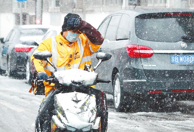 截至2020年底，大陸外送總體訂單量達到171.2億單，圖為外送員在雪中送餐。（中新社）
