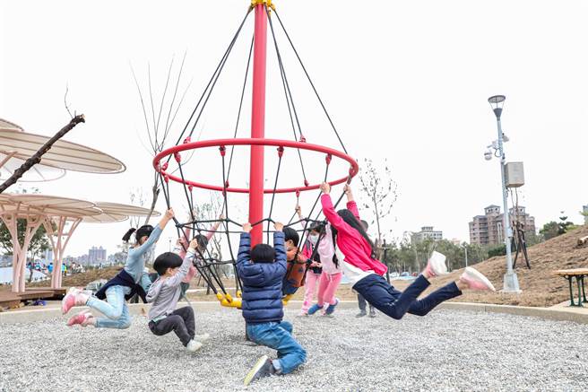 AI智慧园区的绿能公园设置「旋转陀螺」，小朋友很玩的高兴的「飞起来」。（罗浚滨摄）