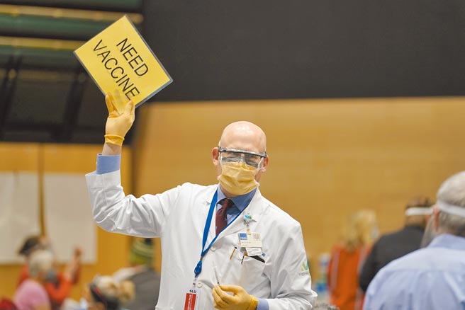 美国西雅图亚马逊公司24日安排员工接种新冠疫苗，图为负责施打疫苗的医生举起手中的牌子，上面写着「需要疫苗」，指示工作人员送去更多疫苗。美国CDC坦承，美国疫苗严重缺货。（美联社）