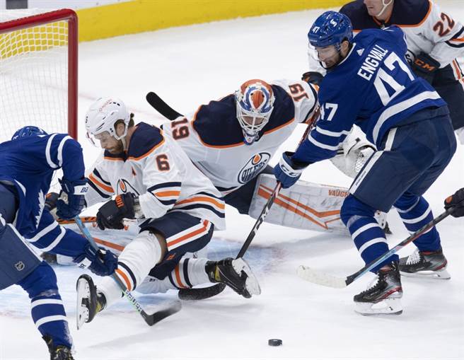 油人队门将柯斯基寧(中)与队友共同封阻对手进攻。（美联社资料照）