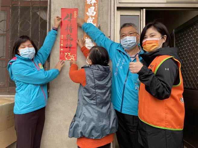 新竹县政府秘书长陈季媛（左）、社会处长李国禄（右二）、蔡衍明爱心基金会经理徐海伦（右一），协助洪女士张贴春联牛转乾坤，期盼新年有新气象。（庄旻静摄）