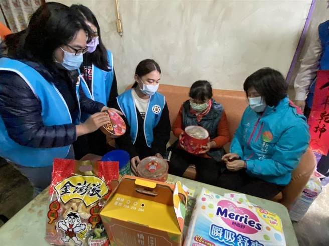 敏实科技大学学生送上餐饮系准备的2道年菜，慰问蔡先生夫妻，并教导简易加热方式。（庄旻静摄）