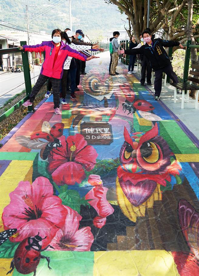 健民里长林进兴（右1）指出，健民里这一段自行车道的特色就是3D彩绘猫头鹰。（黄国峰摄）
