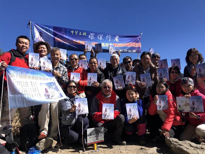 「恭贺新书完成！」当攀上玉山前峰，眾人一边齐声同贺一边拉起布条，人手一本《牛背上的环保行者─张祖恩》。(成功大学提供／曹婷婷台南传真)