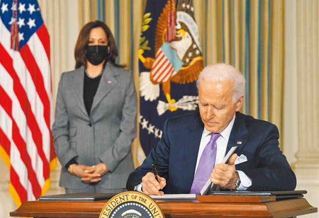 美国总统拜登26日签署一项备忘录，禁止联邦政府使用「中国病毒」一词，以避免涉及种族歧视，后方为副总统贺锦丽。（路透）