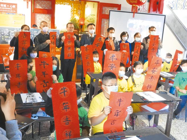 南投县鱼池国小学童完成书法春联后，透过远端萤幕和大陆练市小学的师生们展示，别有寓教于乐的意义。（南投县政府提供／黄立杰南投传真）