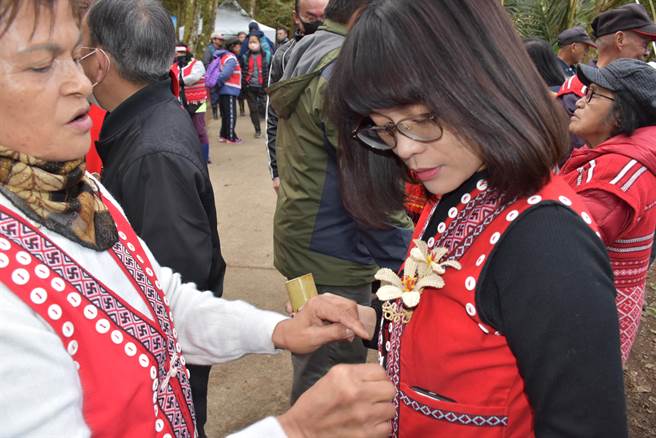 蓬莱村长潘三妹（左）亲手以藤心编造南庄橙花，亲手替蓬莱国小校长林恩惠戴上。（谢明俊摄）