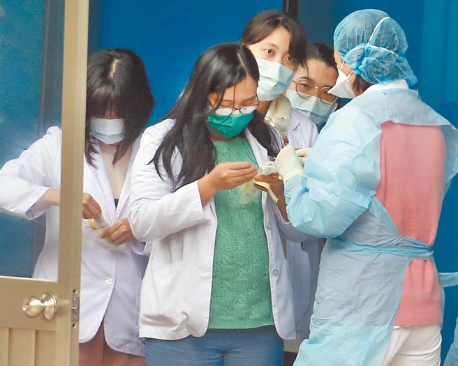 桃园医院发生群聚感染引发全民关注，解除隔离者日前已开始分批採检，在桃园医院的户外诊疗区，院内医护人员排队准备採检。（范扬光摄）