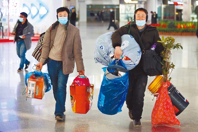 28日是大陆春运首日，疫情之下显得冷清。图为高铁南京站乘客大包小包准备返乡过年。（中新社）