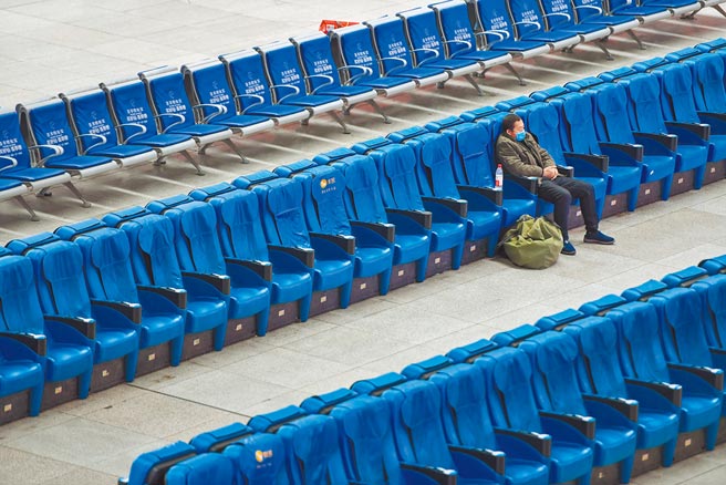 长春站候车大厅不见昔日春运人潮，只有一个乘客孤伶伶地等车。（新华社）