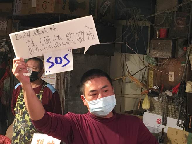 有摊商高举标语「2024总统好」，希望「未来总统」桃园市长郑文灿能救摊商。(蔡依珍摄)