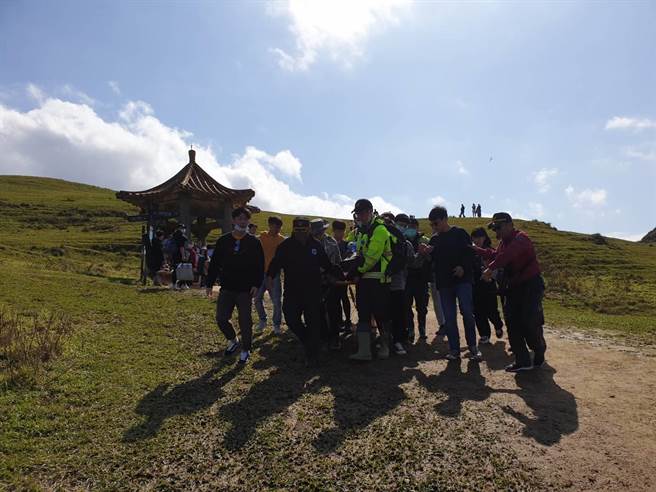 警消出动11人将男子抬下山，送往贡寮保健站急救，目前仍在急救中。（翻摄）