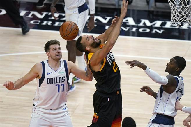 爵士中鋒戈貝爾上籃時遭到獨行俠前鋒芬利史密斯(右)打手犯規。(美聯社)