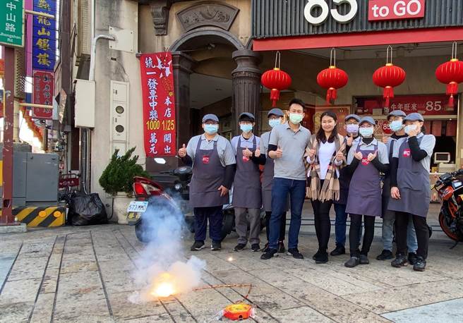 店家下午在店门口放鞭炮庆贺，并在门口悬挂红布条。（谢琼云摄）