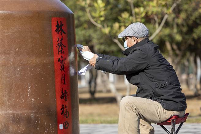 金门县林务所一年一度的假日花市今天登场，邀请当地书法学会在60个1000公升大酒瓮挥毫之一。（金门县林务所提供）