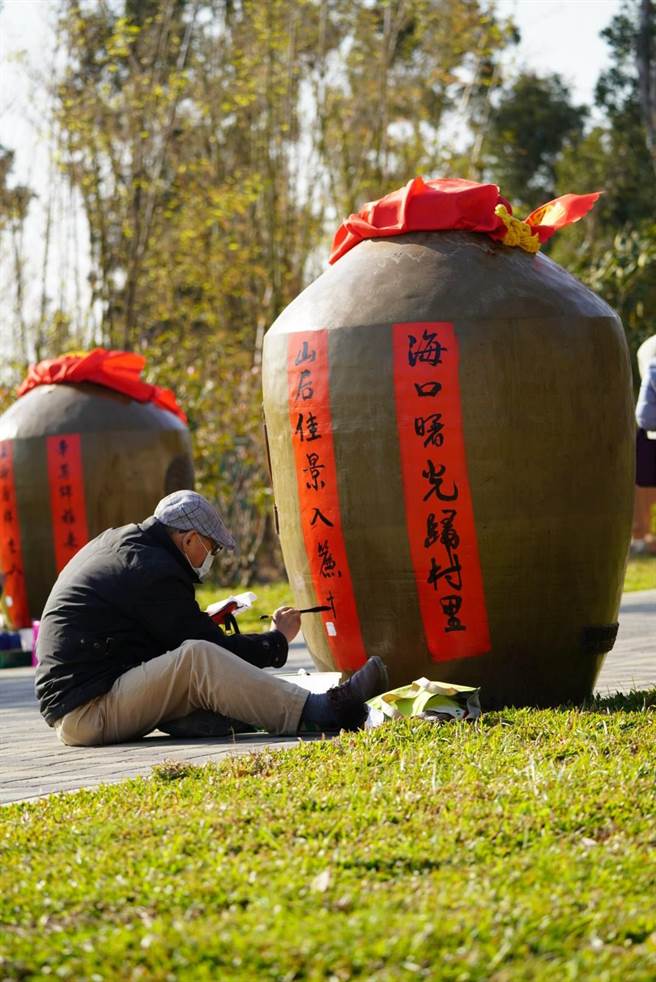 金门县林务所一年一度的假日花市今天登场，邀请当地书法学会在60个1000公升大酒瓮挥毫之二。（金门县林务所提供）