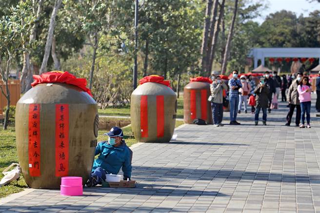 金门县林务所一年一度的假日花市今天登场，邀请当地书法学会在60个1000公升大酒瓮挥毫之三。（金门县林务所提供）