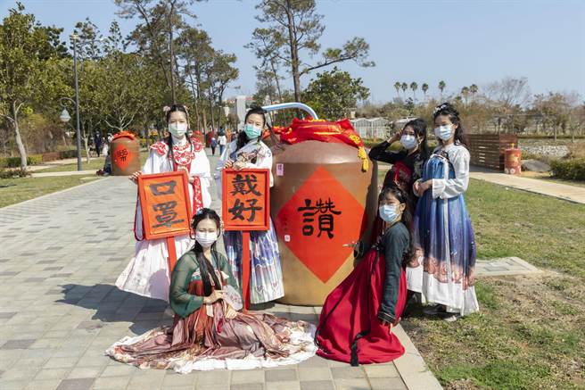 现场用大酒瓮舖排视觉主题外，也有6位来自不同学校的老师穿着汉服，在书法老师挥毫时协助传递笔墨并与游客合照。（金门县林务所提供）