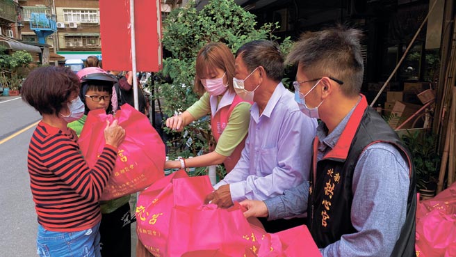 新北市议员彭佳芸（右三）、三重区博爱里里长林广（右二）、新北拱心宫理事长邱昱超（右一）赠送物资给弱势，民眾开心排队领取物资。     图／王盈文提供