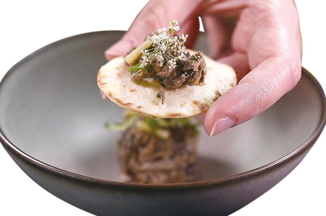 〈黑鸡／黑蒜／黑菜脯〉的第一吃是将用黑蒜美乃提味的拔丝鸡肉卷在小饼内享用。图／姚舜