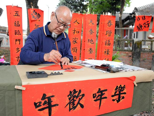 张启祥提笔写春联，希望摆摊卖字的收入能捐给长照机构，也顺势为长照中心老友加菜。（林和生摄）