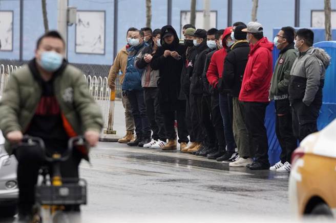 大陸安全人員以人牆阻擋國際媒體接近正進入武漢海鮮市場的世衛專家組，同時也阻擋民眾靠近。（圖／美聯社）