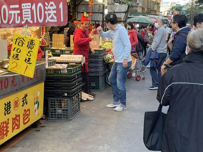 費鴻泰在永春市場巧遇「財神爺」，兩人互相擊肘行「防疫特別恭喜禮」，互相祝賀新年快樂。（費鴻泰提供）