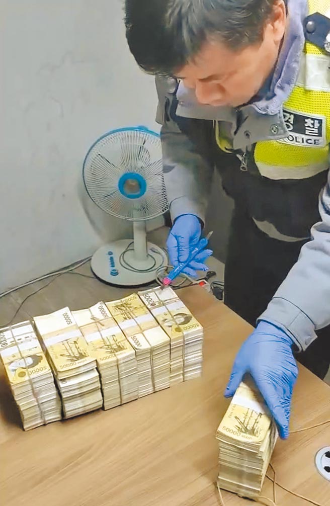 竹联帮天蝎堂陈姓堂主涉嫌替林姓商人地下匯兑韩元，林在台湾交付1500万新台币，赴韩国领到的5亿5000多万韩元，却仅上下几张是真钞，其余均是玩具假钞。图为南韩警方查验这批偽钞。（警方提供／陈鸿伟台北传真）