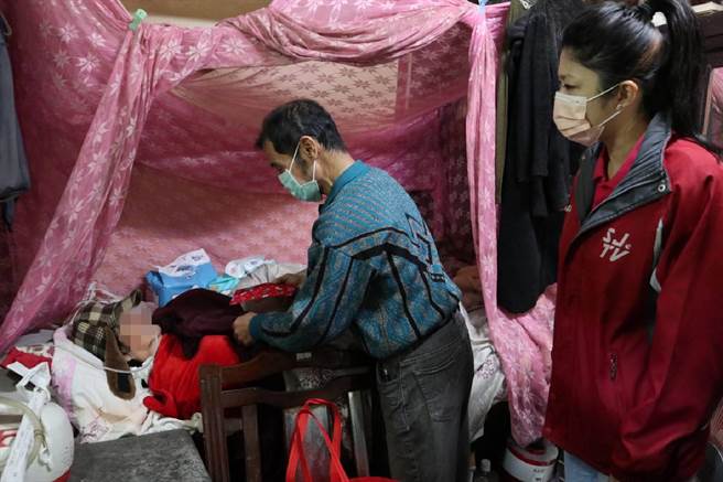 林大哥（中）拿着红包给卧床的林阿嬷。（张毓翎摄）