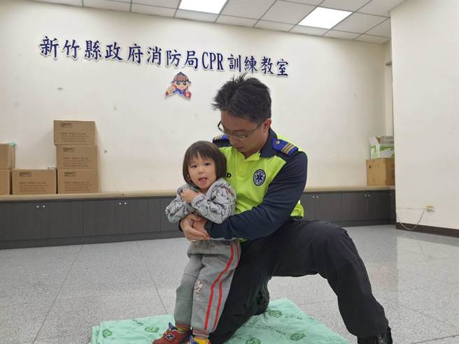 幼儿哈姆立克方式与成人相同，但需蹲下配合患者高度。（新竹县消防局提供／罗浚滨新竹传真）