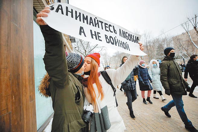 俄罗斯反对派领袖纳瓦尼的支持者1月31日不畏严寒走上首都莫斯科街头，要求当局释放纳瓦尼。2名支持者并当街亲吻，他们所举的标语写着：「作爱不要作战」。（路透）