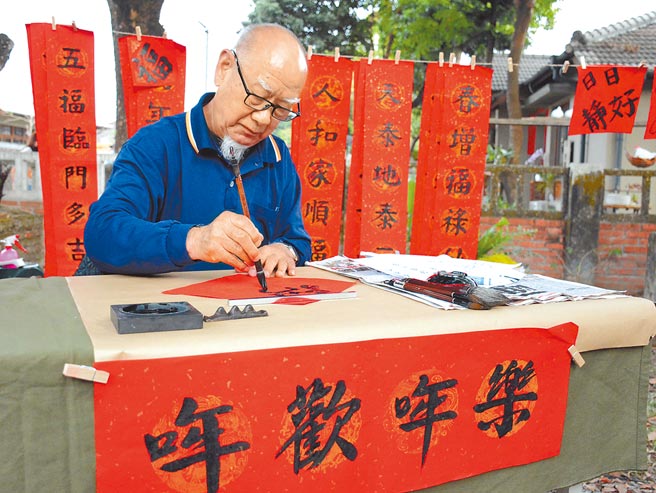 张启祥提笔写春联，希望摆摊卖字的收入能捐给长照机构，也顺势为长照中心老友加菜。（林和生摄）