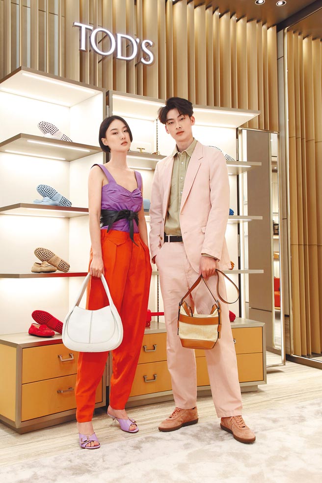 模特儿身着TOD'S春夏服装，展现唯美义式风情。（左）模特儿手拎TOD'S Shirt Bag白色肩背包5万6300元、紫丁香浪漫水晶跟鞋2万2500元。（右）模特儿手拎皮革帆布拼接提包4万6900元、麂皮復古豆豆鞋2万3000元。（TOD'S提供）