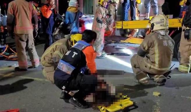 车祸受困的伤者被救出后，消防人员在场进行初步急救。（洪荣志摄）