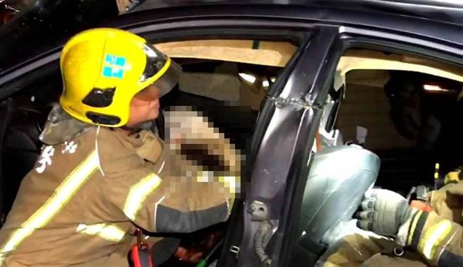 消防人员抢救受困车内的伤者。（洪荣志摄）